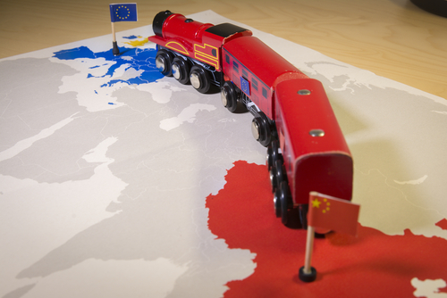 Toy train on map of China and Europe.
